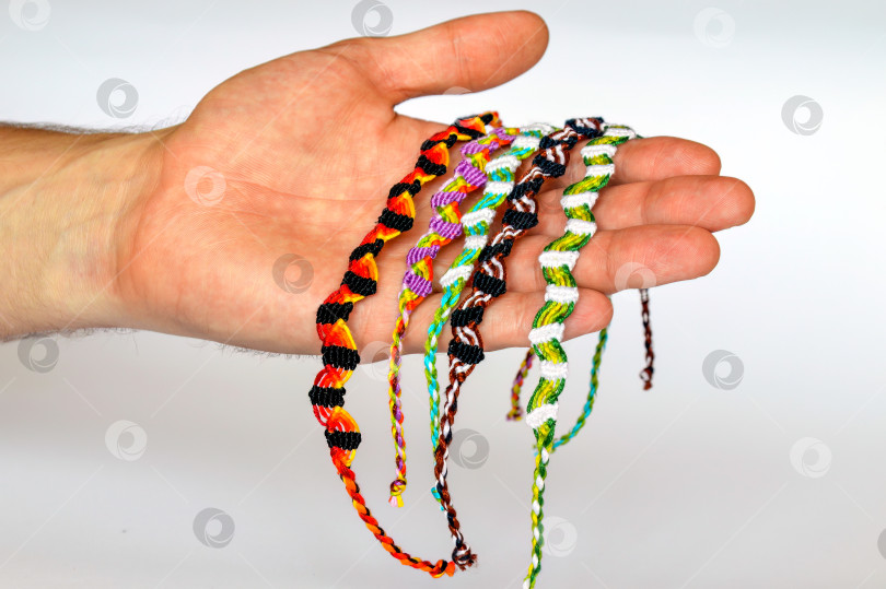 Скачать Плетеные браслеты дружбы ручной работы из ниток на мужскую руку. фотосток Ozero