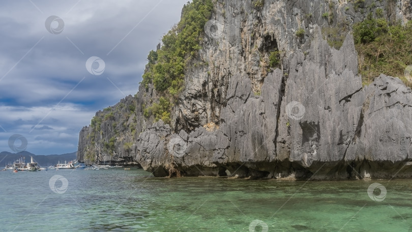 Скачать Отвесные карстовые скалы возвышаются над водой. фотосток Ozero