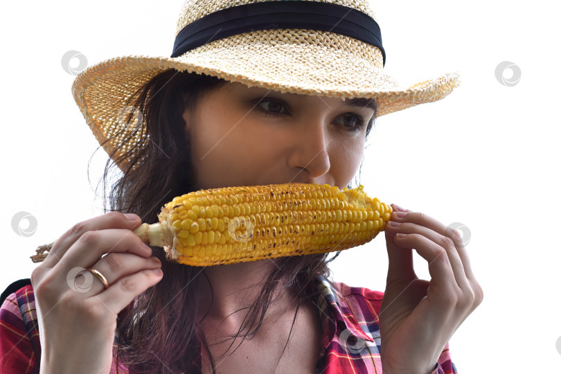 Скачать Молодая женщина в шляпе ест жареную кукурузу на белом фоне фотосток Ozero
