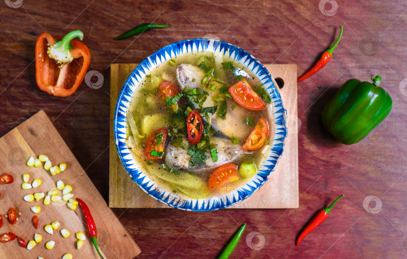 Скачать Вьетнамский суп с рыбой и овощами на деревянном столе фотосток Ozero