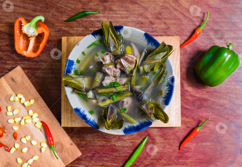 Скачать Вьетнамский суп с рыбой и артишоками на деревянном столе фотосток Ozero