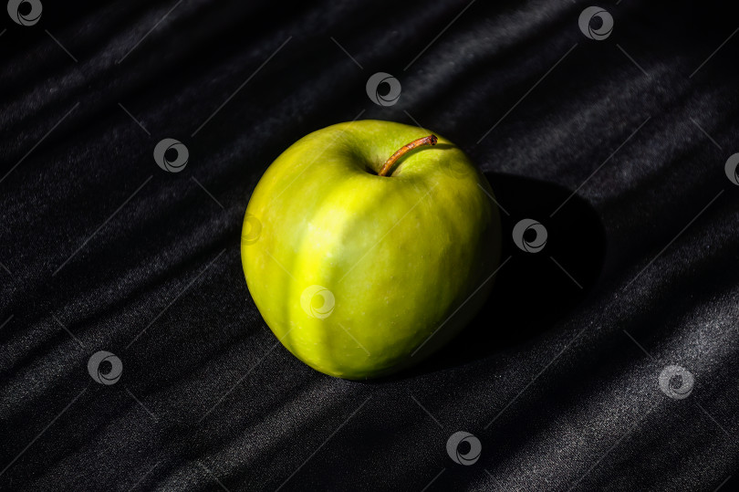 Скачать Большое зеленое яблоко на полосатом темно-сером и светло-сером фоне фотосток Ozero