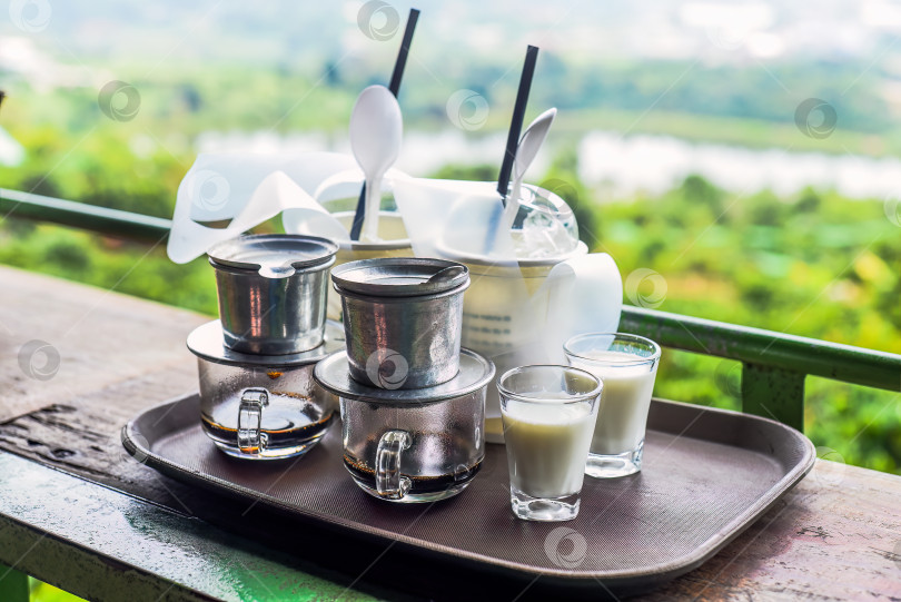 Скачать Традиционный вьетнамский кофе с молоком на деревянном столе фотосток Ozero