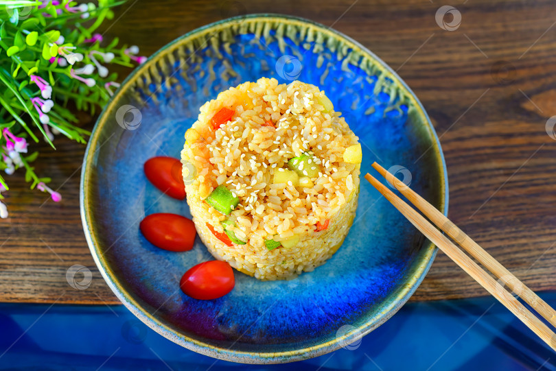 Скачать Жареный рис с паприкой и цуккини, украшенный помидорами черри. для меню азиатской кухни фотосток Ozero