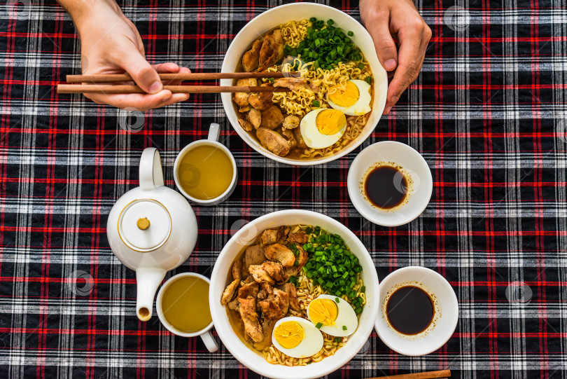 Скачать Кусочек курицы на палочках для еды с японским раменом и мужскими руками фотосток Ozero