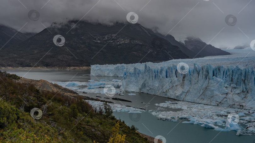 Скачать Стена голубого потрескавшегося ледника над ледниковым бирюзовым озером. фотосток Ozero