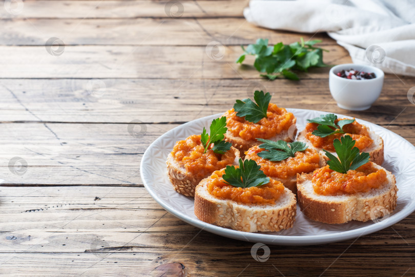 Скачать Бутерброды с хлебом, кабачковой икрой, помидорами и луком. Вегетарианские блюда домашнего приготовления. Консервированные тушеные овощи. пространство для копирования деревянного фона фотосток Ozero