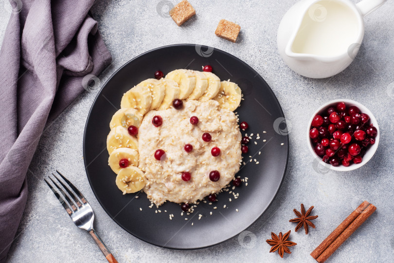 Скачать Овсяная каша на молоке с бананом, клюквой и кунжутом. Чашечка кофе - концепция здорового завтрака. фотосток Ozero