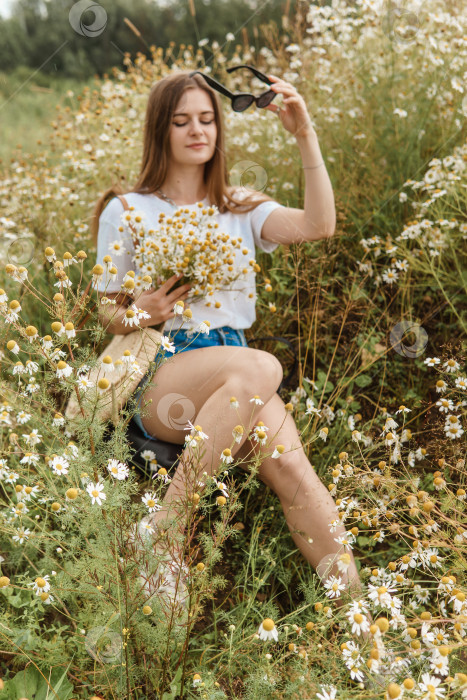 Скачать Красивая молодая женщина на природе с букетом ромашек. Полевые маргаритки, поле цветов. фотосток Ozero