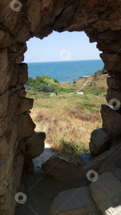 Скачать Вид на Феодосийскую бухту через бойницу Генуэзской крепости. фотосток Ozero