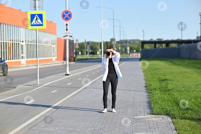 Скачать Красивая женщина фотографирует на открытом воздухе аналоговой камерой фотосток Ozero