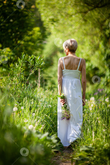 Скачать взрослая женщина в длинном белом платье ранним солнечным утром на размытом фоне с эффектом боке фотосток Ozero
