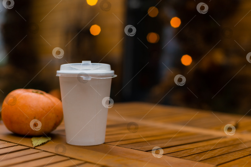 Скачать макет белого картонного стаканчика для кофе и маленькой тыквы на осеннем фоне в стиле боке фотосток Ozero