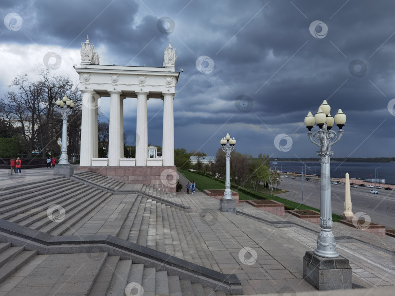 Скачать Волгоградская набережная вид на колоннаду и площадь перед фонтаном в солнечный день и предгрозовое небо фотосток Ozero