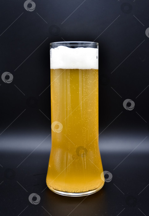 Скачать стеклянная колба на черном фоне с желтой жидкостью и белой пеной, бокал пива на черном фоне фотосток Ozero