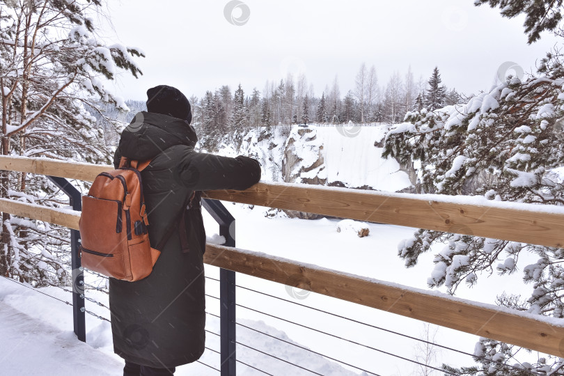 Скачать девушка стоит на мосту и смотрит на зимний пейзаж фотосток Ozero