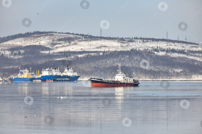 Скачать Мурманск, Россия - 7 марта 2021 года: корабль плывет по морю на фоне заснеженных гор. фотосток Ozero