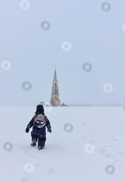 Скачать Колокольня посреди замерзшего озера, ребенок, идущий сзади. фотосток Ozero