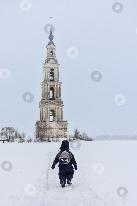 Скачать Колокольня посреди замерзшего озера, ребенок, идущий сзади. фотосток Ozero