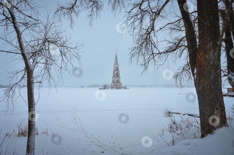 Скачать Колокольня посреди замерзшего озера, между деревьями фотосток Ozero