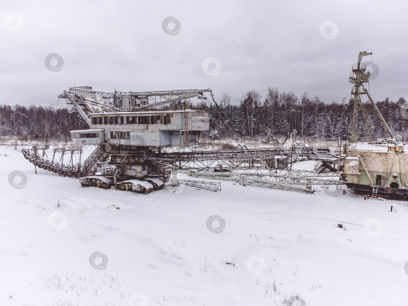 Скачать заброшенный гигантский роторный экскаватор стоит зимой в поле фотосток Ozero