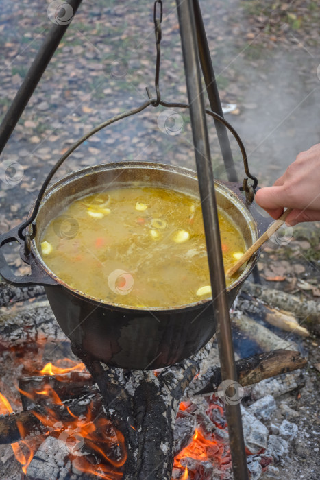 Скачать приготовление пищи в котелке на костре, походная стряпня, котелок с горячей пищей фотосток Ozero