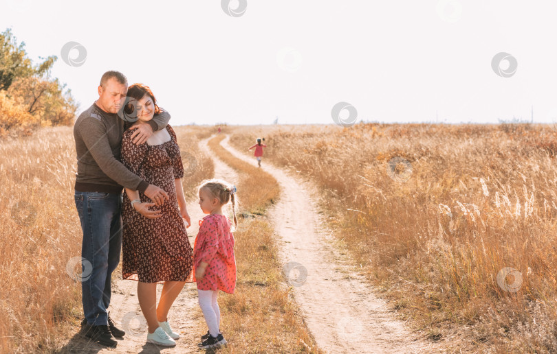 Скачать Семья с тройняшкой на прогулке. Счастливые отец и мать фотосток Ozero
