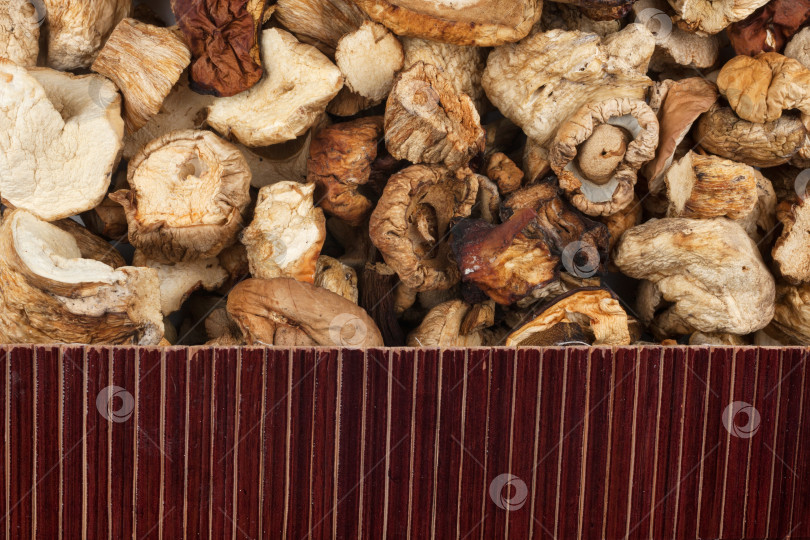 Скачать Красивый бамбуковый коврик на фоне сухих грибов в качестве сельскохозяйственного фона. фотосток Ozero