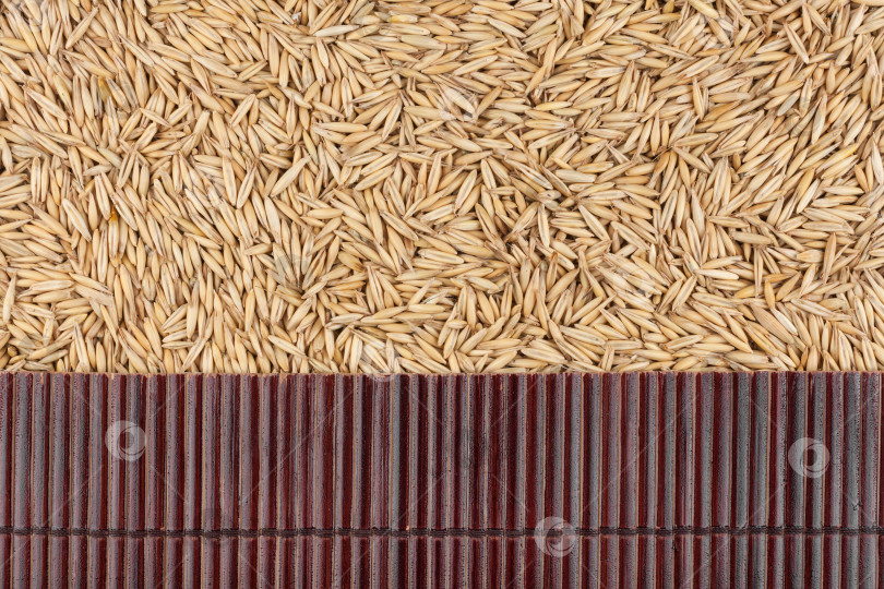 Скачать Красивая бамбуковая циновка на овсяных зернах в качестве сельскохозяйственного фона. фотосток Ozero