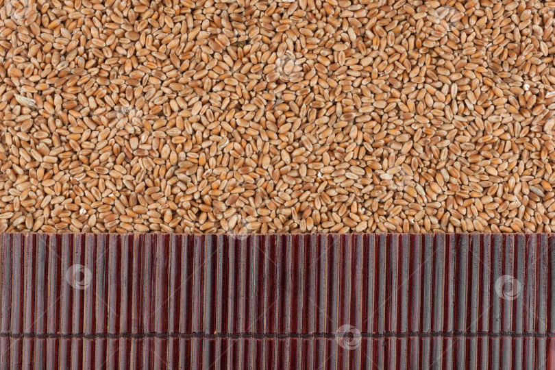 Скачать Красивый бамбуковый коврик на пшеничных зернах в качестве сельскохозяйственного фона. фотосток Ozero