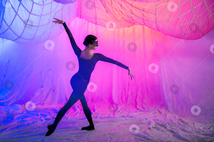 Скачать женщина танцует в комнате с занавесками из тонкой воздушной ткани, освещенной синими и красными прожекторами. фотосток Ozero