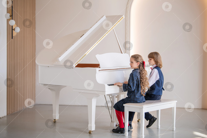 Скачать Двое детей играют на пианино. фотосток Ozero