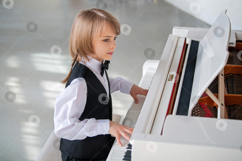 Скачать Маленький мальчик играет на пианино. фотосток Ozero
