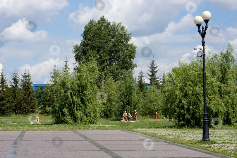 Скачать Городской  парк с загорающими людьми фотосток Ozero