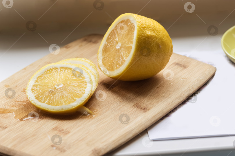 Скачать Сочный лимон нарезать кусочками на разделочной доске. фотосток Ozero