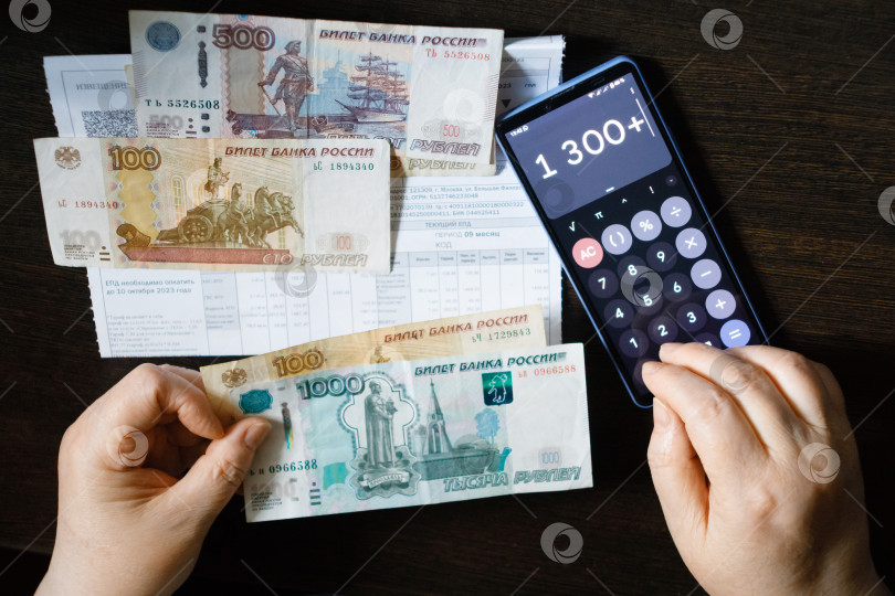 Скачать Пенсионерка держит в своих руках деньги с квитанциями об оплате ЖКУ и пересчитывает их на калькуляторе.
Москва, Россия, 9 июня 2024 года. фотосток Ozero