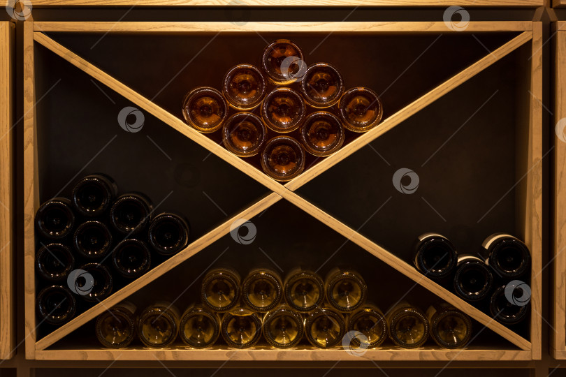 Скачать Винный шкаф из светлого дерева с бутылками белого, розового, оранжевого, красного вина фотосток Ozero