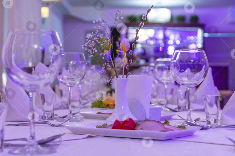 Скачать Красиво накрытый банкетный стол для свадьбы или юбилея в ресторане, ожидающий прибытия гостей в сиренево-розовом свете. фотосток Ozero