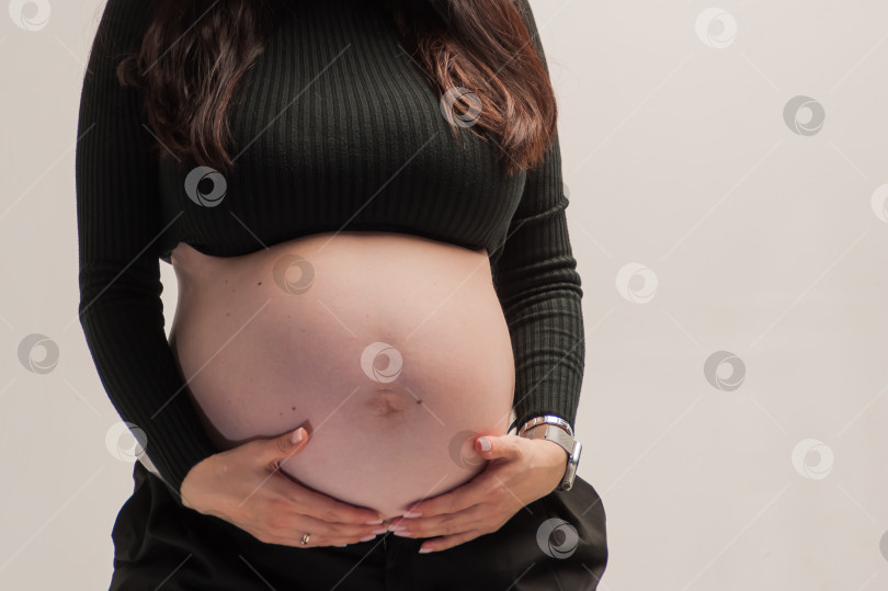 Скачать беременная женщина с большим животом позирует в фотостудии фотосток Ozero