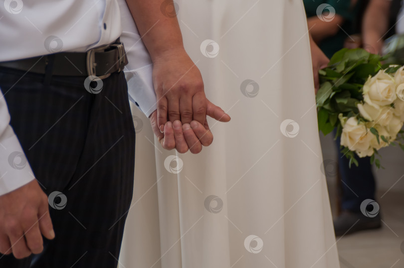 Скачать жених и невеста крепко держат друг друга за руки фотосток Ozero