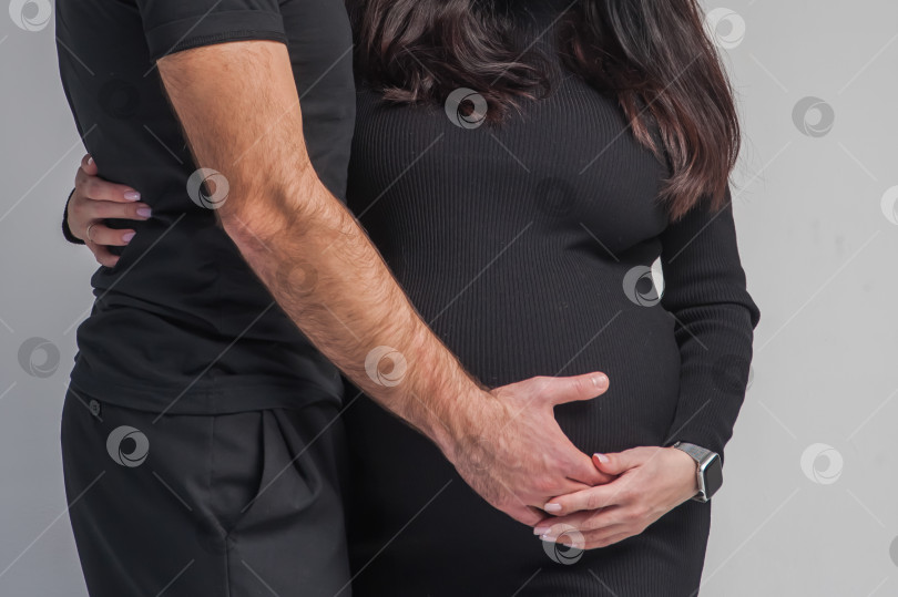 Скачать мужчина и жена в возрасте 40 недель, с большим животом, в черной одежде на белом фоне, стоящие на черном фоне фотосток Ozero