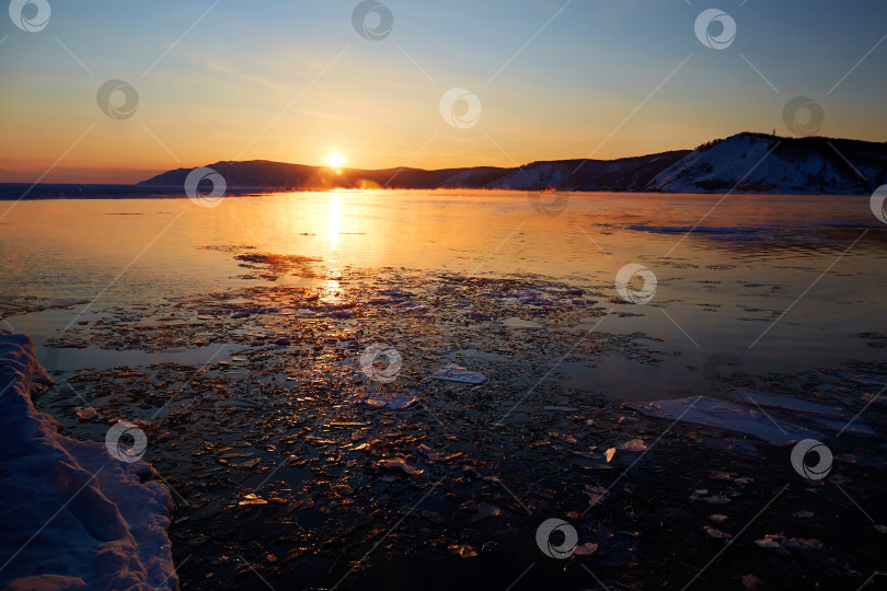 Скачать Прекрасный закат на озере Байкал весной. Тающий лед и открытая вода в озере. фотосток Ozero