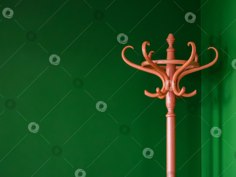 Скачать деревянная напольная вешалка на минималистичном зеленом фоне фотосток Ozero