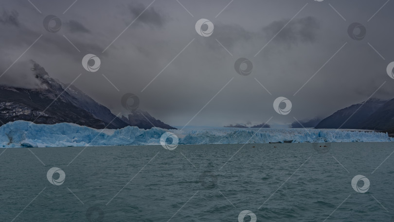 Скачать Стена из голубого льда пересекает бирюзовое ледниковое озеро. фотосток Ozero