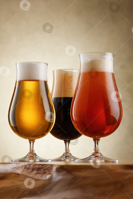 Скачать Три бокала с разными сортами пива на деревянной столешнице. фотосток Ozero