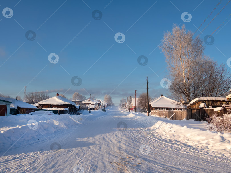 Скачать Заснеженная дорога в сельской местности со снежными заносами морозной зимой. фотосток Ozero