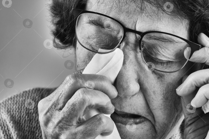 Скачать Пожилая женщина вытирала слезы с глаз носовым платком. фотосток Ozero