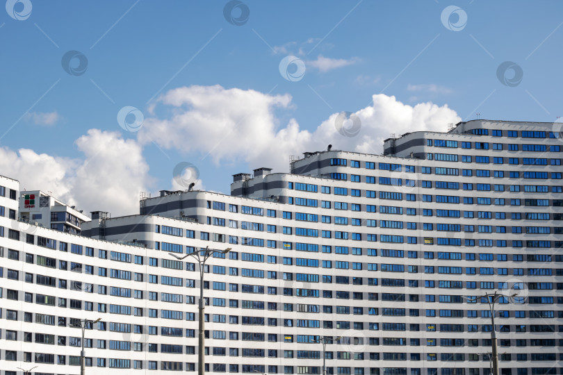 Скачать Беларусь, Минск - 30 мая 2024 года: Высокое здание возвышается на фоне ярко-голубого неба фотосток Ozero