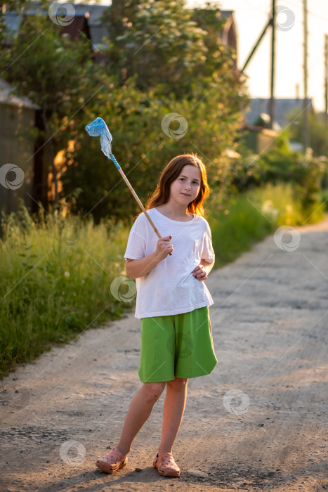 Скачать Симпатичная девушка ловит бабочек сачком летом фотосток Ozero