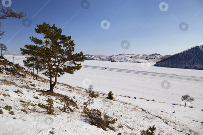 Скачать Автомобиль едет по ледовой дороге к острову Ольхон. фотосток Ozero